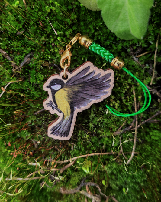 Wooden charm of a Great tit on mossy background.