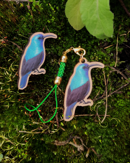 Wooden pin and charm of a Palestine Sunbird on mossy background.