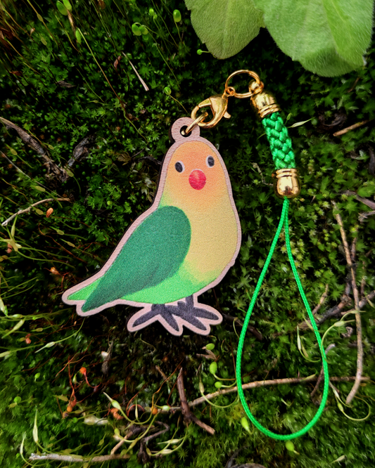 Wooden charm of a Lovebird on mossy background.