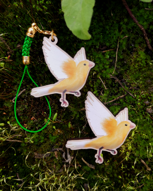 Wooden pin and charm of a Canary on mossy background.