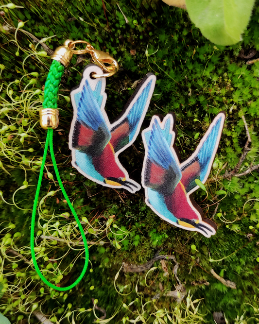 Wooden pin and charm of a European Bee Eater on mossy background.
