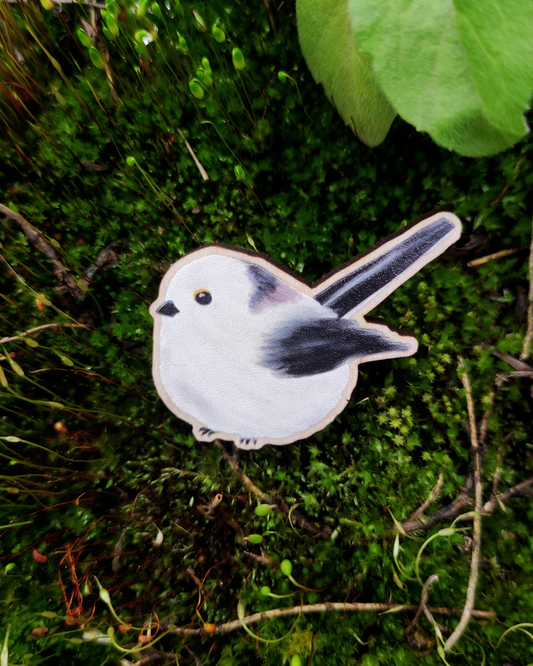 Wooden pin of a Long-tailed tit on mossy background.