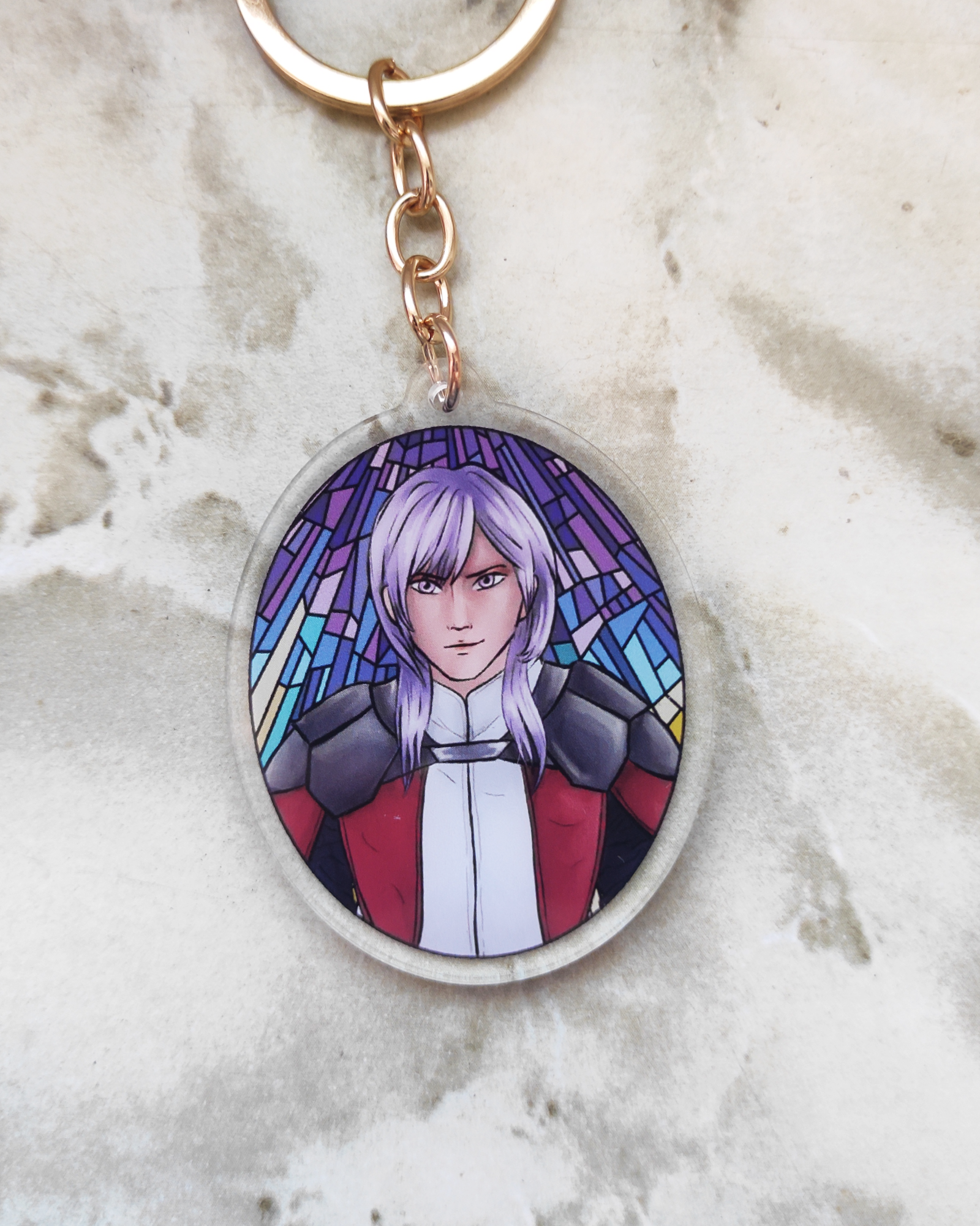 Keychain of Yuri from fire Emblem on a marble surface.