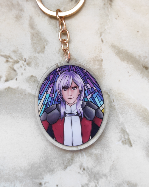 Keychain of Yuri from fire Emblem on a marble surface.