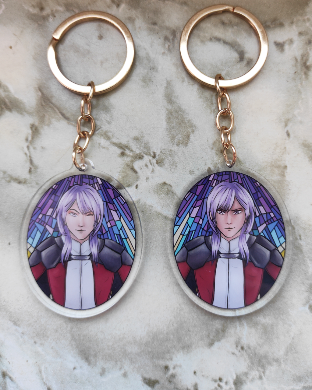 Two keychains of Yuri from Fire emblem. Each side has a different expression.